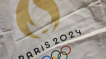 Le logo officiel des Jeux olympiques de Paris 2024, imprimé sur du textile, le 14 août 2023. (ARTUR WIDAK / NURPHOTO / AFP)