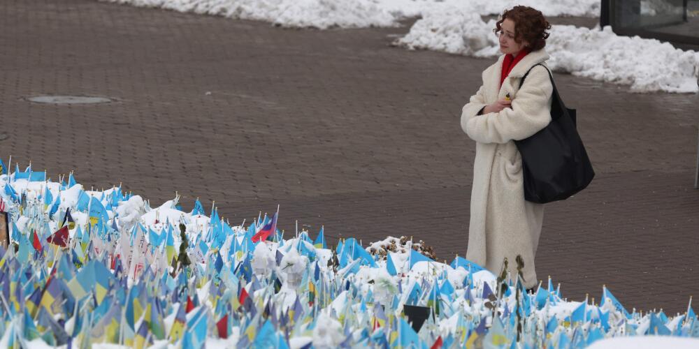 Une femme devant les drapeaux portant les symboles et les couleurs de l’Ukraine en commémoration des soldats ukrainiens morts au combat, sur la place de l’Indépendance, à Kiev, le 1ᵉʳ décembre 2023.